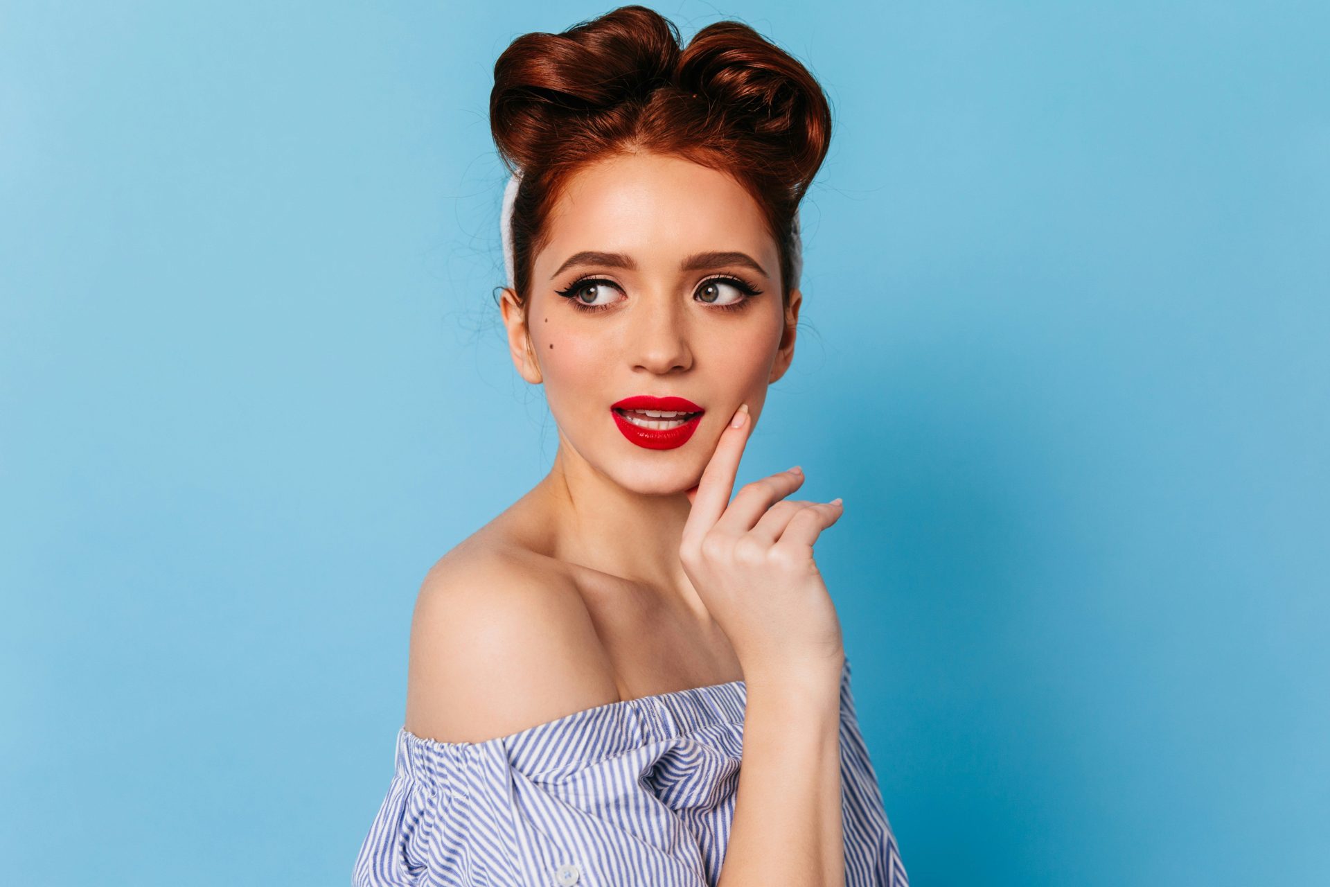 a woman with red lipstick and a bun in her hair